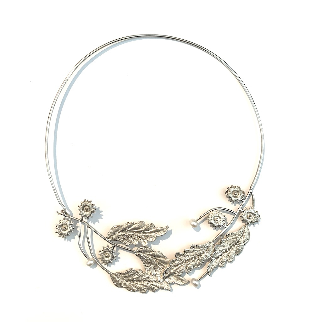 A larger sterling silver neck wire necklace with leaf and flower accents. Hook closure.