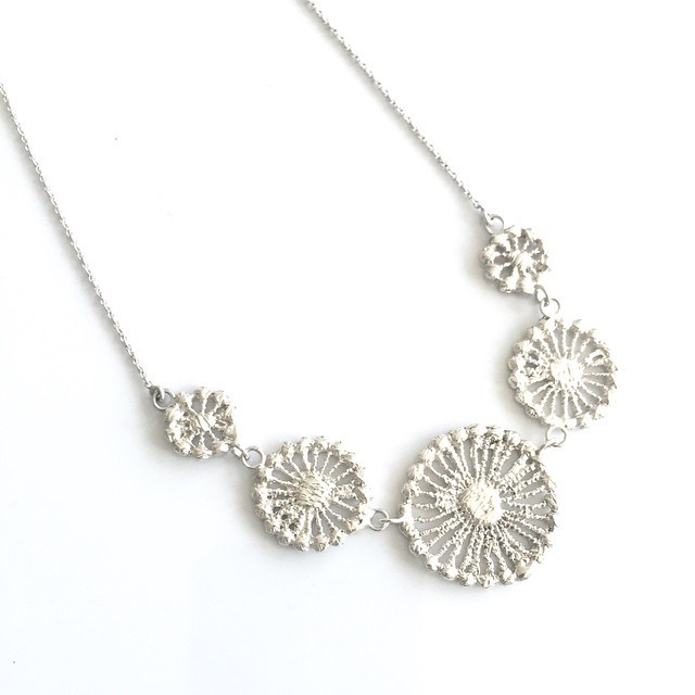 A beautiful necklace made of 5 graduated circular shapes made from lace that was molded and cast into sterling silver.