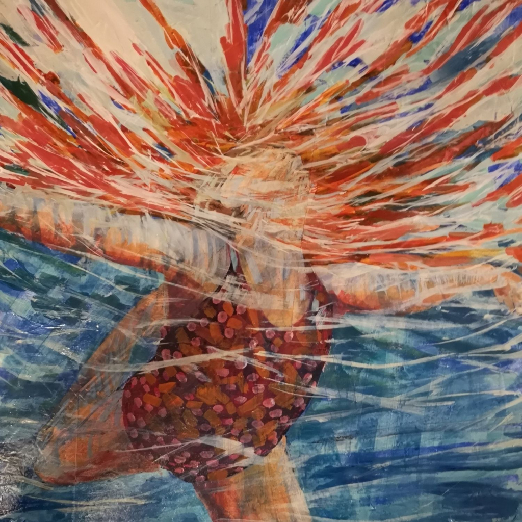 Girl underwater with arms open wide and one leg kicked back