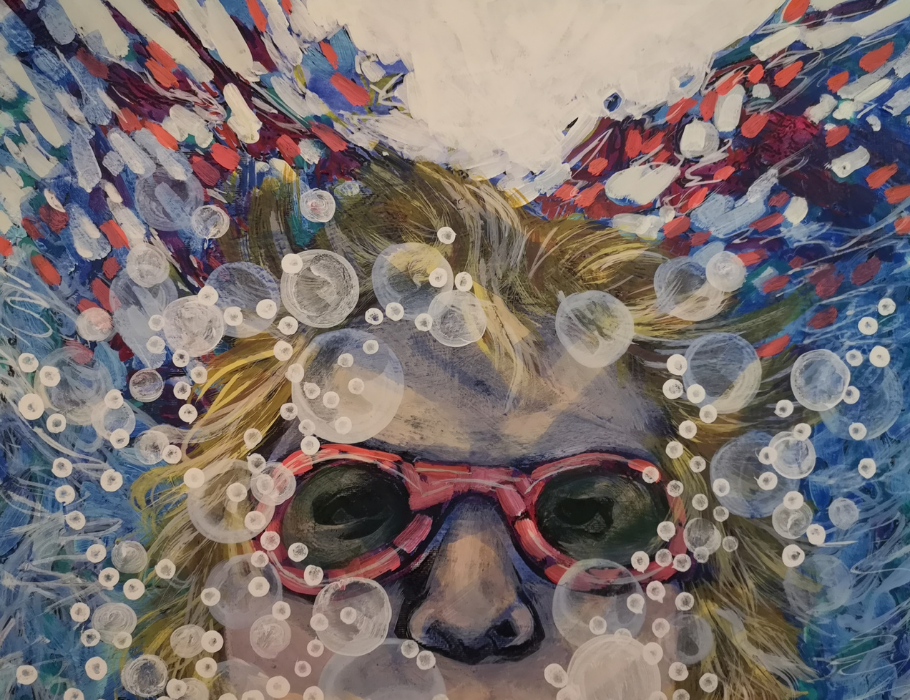 Childs face with swimming goggles underwater with bubbles