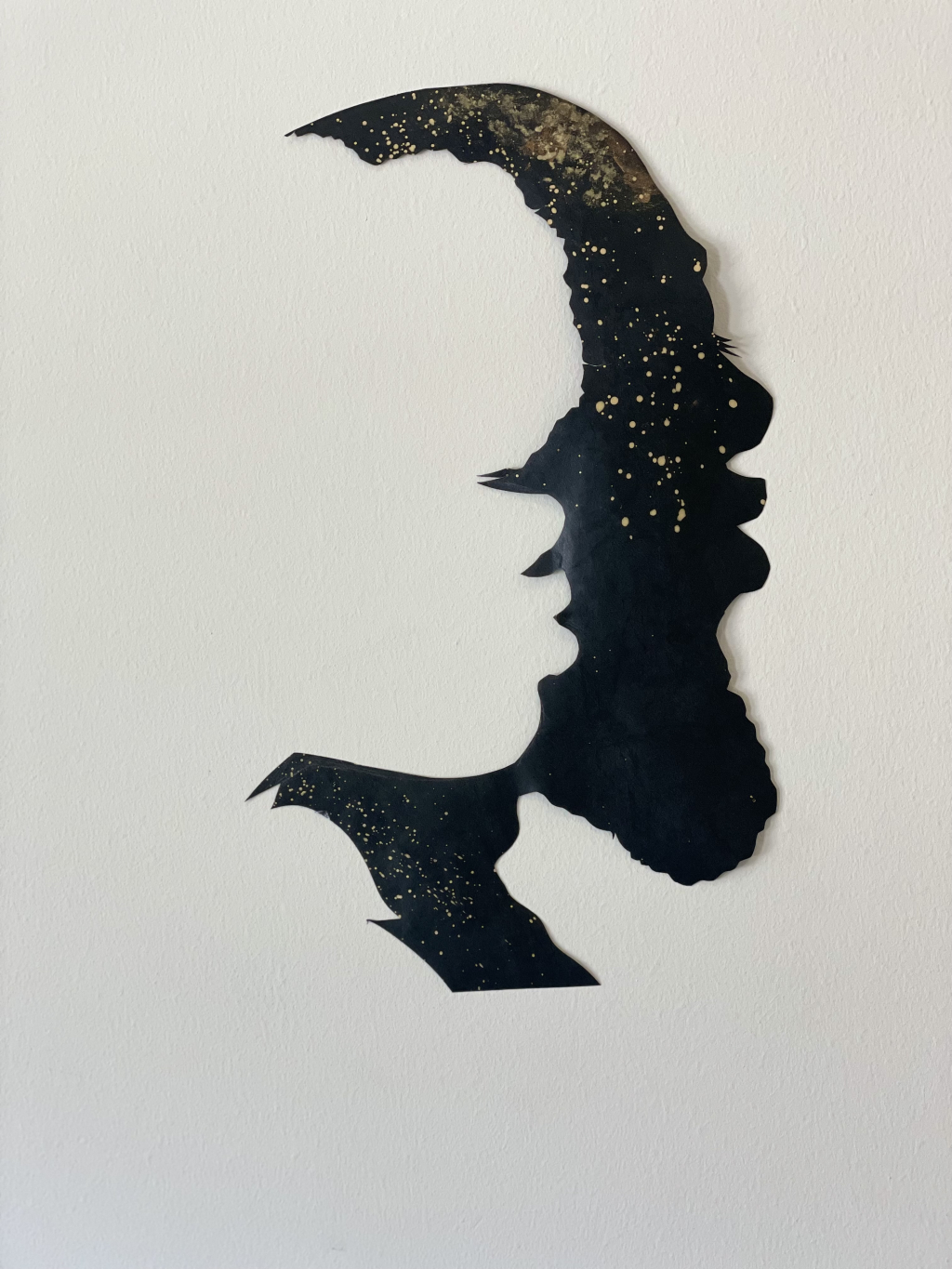 Positive and negative silhouette of two people with gold ink embellishments.