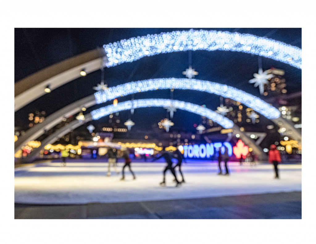 A Blurred photo of figures skating at Nathan Phillips Square.